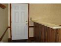 This home features an entryway with a white door, wooden bar counter, and neutral-toned wallpaper at 608 N Ellis Ave, Dunn, NC 28334