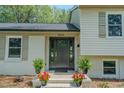 An inviting front entrance with a stylish door, potted plants, and freshly painted brick at 2804 Edgewood Ave, Burlington, NC 27215