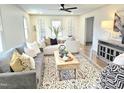 Inviting living room featuring stylish furniture, patterned rug, and a modern ceiling fan at 2804 Edgewood Ave, Burlington, NC 27215
