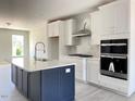 Eat-in kitchen showcasing a large island, white cabinets, stainless appliances, and marble backsplash at 478 Traditions Grande Blvd # 32, Wake Forest, NC 27587