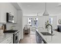 Open-concept kitchen showcases white cabinets, stainless steel appliances, and an island overlooking the living space at 6420 Tanner Oak Ln, Raleigh, NC 27613