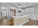 Bright and open kitchen with white cabinets, island with light wood accent, and stainless appliances at 703 Jamescroft Way, Rolesville, NC 27587