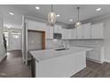 Bright kitchen featuring white cabinets, stainless steel appliances, and a central island with pendant lighting at 707 Jamescroft Way, Rolesville, NC 27587