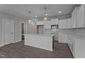 Bright kitchen featuring white cabinets, stainless steel appliances, and a central island with pendant lighting at 707 Jamescroft Way, Rolesville, NC 27587