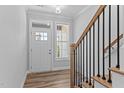 Bright entryway featuring wood-look flooring, natural wood stairs with black wrought iron spindles at 709 Jamescroft Way, Rolesville, NC 27587