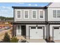 Charming two-story townhome with grey siding, white trim, and a one-car garage offers modern curb appeal at 709 Jamescroft Way, Rolesville, NC 27587
