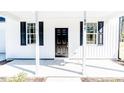 Close-up of the front porch with white columns and a black front door at 806 Roberts Rd, Sanford, NC 27332