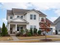 Beautiful two-story home boasts a welcoming front porch and well-manicured landscaping at 108 Scarlet Tanager Cir, Holly Springs, NC 27540