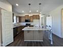Open kitchen with an island, modern appliances, granite counters, and ample cabinet space at 155 Waterwheel Dr, Selma, NC 27576