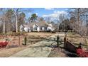 Long driveway leading to a white house with landscaping and brick pillars at 319 Fox Hollow Dr, Clayton, NC 27527