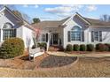 House entrance with brick steps, white exterior, landscaping, and a white bench at 319 Fox Hollow Dr, Clayton, NC 27527