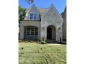 Stylish two-story home with white brick facade, arched entryway, and well-manicured lawn at 3302.5 Hall Pl, Raleigh, NC 27607