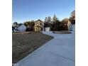 Two-story house, gray siding, white garage doors, curved driveway, and wooded lot at 788 Roberts Rd, Sanford, NC 27332