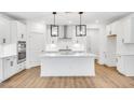 Stylish kitchen boasts an island, stainless steel appliances, and sleek white cabinetry at 800 Heathered Farm Way, Apex, NC 27523