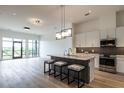 Modern kitchen with white cabinets, stainless steel appliances, gray backsplash, and island with seating at 120 Mosaic Blvd # 307, Pittsboro, NC 27312