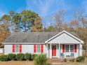 Gray house with red shutters, a covered porch, and landscaping at 512 Drexel Rd, Rocky Mount, NC 27803