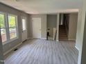 Open-concept living room with lots of natural light, new floors, and stairway access to the second level at 1017 Gaston Ave, Durham, NC 27707