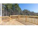 A wooden deck and railing face an open backyard and forest at 120 Tobacco Woods Dr, Youngsville, NC 27596
