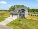 Charming two-story home with a stone facade, long driveway and manicured lawn at 150 Whimbrel Ct, Lillington, NC 27546