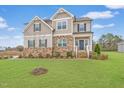 Charming two-story home featuring a stone facade, neutral siding, and a well-manicured front lawn at 254 Dungannon, Clayton, NC 27520