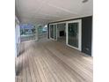 Relaxing outdoor porch with wood flooring, white railing, and sliding glass doors for indoor-outdoor living at 3302 Hall Pl, Raleigh, NC 27607