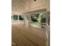 Inviting outdoor porch boasts white columns, a wood floor, and a backyard view with lush greenery at 3302 Hall Pl, Raleigh, NC 27607