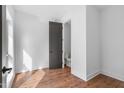Bright bedroom featuring hardwood floors, white walls and trim, and a large door that leads to a bathroom at 512 Gordon Street # 602, Durham, NC 27701