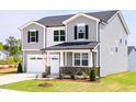 Two-story home featuring a two-car garage, stone accents, and beautifully landscaped front yard at 59 Davinhall Dr, Fuquay Varina, NC 27526