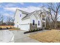 Modern two-story home featuring white siding, stone accents, an attached garage, and a covered balcony at 89 Jumper St, Wendell, NC 27591