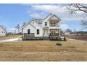 Beautiful two-story home with white siding, stone accents, a covered balcony, and manicured lawn at 89 Jumper St, Wendell, NC 27591