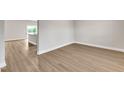 Open-concept living area with luxury vinyl plank flooring, bright light and neutral paint at 107 Wilderness Ct, Mebane, NC 27302