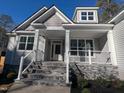 Charming home entrance with stone stairs, white columns and welcoming front porch at 129 Mayan Dr, Louisburg, NC 27549