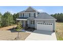 Charming two-story home featuring a front porch, two-car garage, and a well-manicured lawn and mature trees at 40 Misty Mountain, Spring Hope, NC 27882