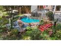 Backyard pool featuring a waterfall, stone surround, bridge and lush landscaping at 5317 Burning Oak Ct, Raleigh, NC 27606