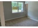 Cozy bedroom with neutral carpet, a bright window, and a view of the outdoors at 114 Arundel Dr, Archer Lodge, NC 27527