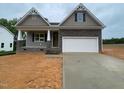 New construction home featuring stone accents, a two-car garage, and a charming covered porch at 114 Arundel Dr, Archer Lodge, NC 27527