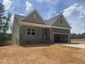 Charming new construction home featuring stone accents, a two-car garage, and a welcoming covered front porch at 114 Arundel Dr, Archer Lodge, NC 27527