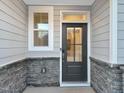 Exterior front door detail with stone and gray wood siding at 203 Pond Vw Ct # 1, Fuquay Varina, NC 27526