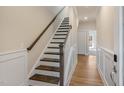 Inviting hallway with beautiful wainscoting and hardwood floors leading to an open layout at 207 Pond View Ct # 3, Fuquay Varina, NC 27526