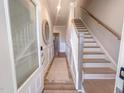 Bright hallway with wood floors, white wainscoting, decorative mirror and staircase at 209 Pond View Ct # 4, Fuquay Varina, NC 27526