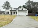 Two-story white farmhouse with a two car garage and driveway at 601 Vannoy Pl, Fuquay Varina, NC 27526