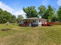 Spacious yard with a home featuring a vibrant deck, perfect for outdoor relaxation and entertaining guests at 670 Mcadams Rd, Hillsborough, NC 27278