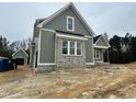 Side view of a new construction home with brick accents and covered porch with wooden posts at 136 Bar Code Ct, Wendell, NC 27591