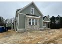 Angle side view of a new construction home with brick accents and covered porch with wooden posts at 136 Bar Code Ct, Wendell, NC 27591