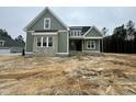 Newly constructed home with olive siding, grey brick and a covered front entrance at 136 Bar Code Ct, Wendell, NC 27591