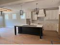 Bright kitchen featuring a central island, modern lighting and white cabinets at 136 Bar Code Ct, Wendell, NC 27591
