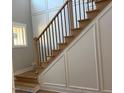 Elegant stairway with wooden treads, wrought iron balusters, and decorative wall molding provides a sophisticated touch at 136 Bar Code Ct, Wendell, NC 27591