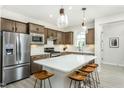 Open kitchen with a large island, stainless steel appliances, and seating, perfect for entertaining guests at 2308 Beeblossom Pl, Fuquay Varina, NC 27526