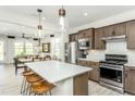Modern kitchen featuring stainless steel appliances, a center island with seating, and stylish pendant lighting at 2308 Beeblossom Pl, Fuquay Varina, NC 27526