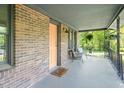 Charming front porch with brick accents, cozy seating, and hanging plants, perfect for relaxing outdoors at 320 W Orange St, Hillsborough, NC 27278